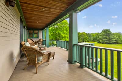Spacious covered porch overlooking lush greenery, perfect for relaxation and outdoor gatherings.
