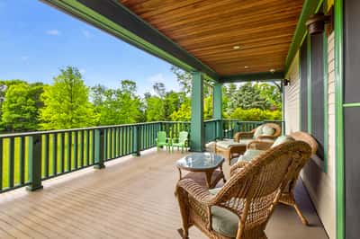 Relax on this spacious porch, surrounded by lush greenery and stunning views, perfect for outdoor gatherings.