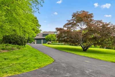 Discover this inviting home set amidst lush greenery, featuring a spacious driveway and panoramic views.