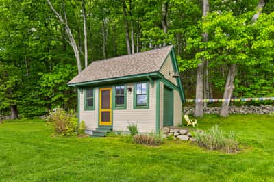 Quaint cottage nestled in lush greenery, featuring vibrant accents and a peaceful outdoor space for relaxation.