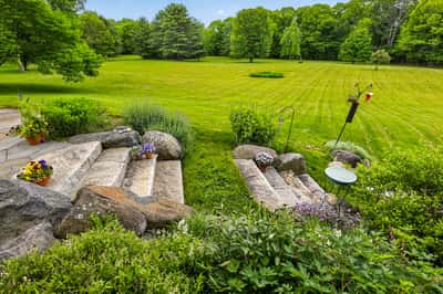 Discover a tranquil outdoor retreat featuring landscaped steps leading to expansive, lush greenery and open space.