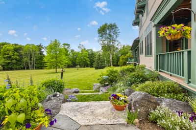 Discover a spacious outdoor retreat surrounded by lush greenery and vibrant perennial gardens, perfect for relaxation.