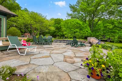 Spacious outdoor patio surrounded by lush greenery, perfect for gatherings and enjoying nature's beauty.