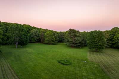 Expansive, lush green landscape with mature trees, perfect for outdoor activities or building your dream home.