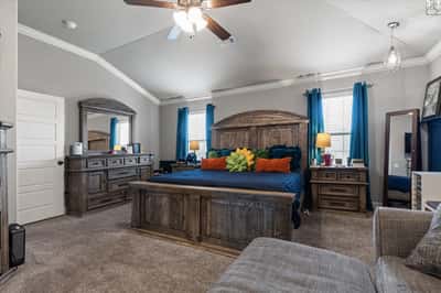 Spacious primary suite featuring high ceilings, ample natural light, and a cozy seating area for relaxation.