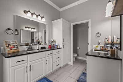 Modern bathroom featuring dual sinks, ample storage, and contemporary fixtures, perfect for daily routines.