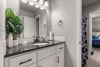 Modern bathroom featuring sleek countertops, ample storage, and a Jack and Jill for convenience.