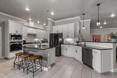 This modern kitchen features sleek cabinetry, a spacious island, and contemporary appliances, perfect for culinary enthusiasts.