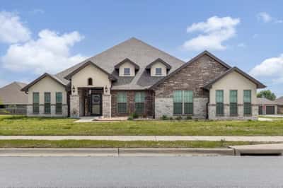 Spacious home featuring a unique design, ample natural light, and an inviting front yard in a vibrant neighborhood.