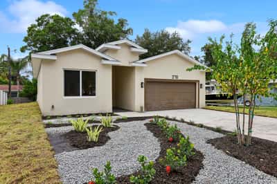 Modern home featuring a landscaped front yard, two-car garage, and a welcoming entrance. Perfect for families!