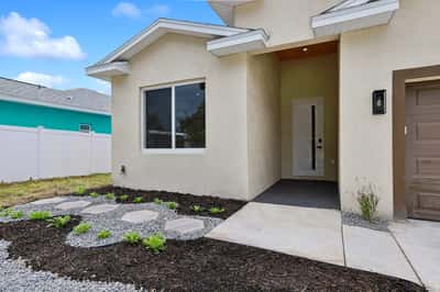 Contemporary home entrance featuring a spacious porch and low-maintenance landscaping, perfect for outdoor enjoyment.