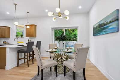Bright and inviting dining area featuring modern furnishings and natural light, perfect for gatherings and meals.