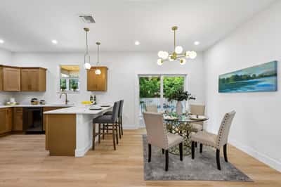 Bright and modern dining area featuring a sleek kitchen, perfect for gatherings and everyday meals.