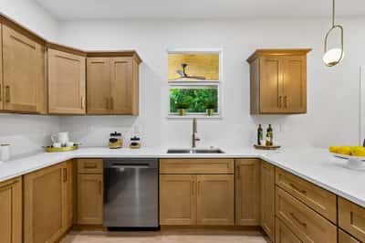Modern kitchen featuring sleek cabinetry, stainless steel appliances, and abundant natural light from large window.