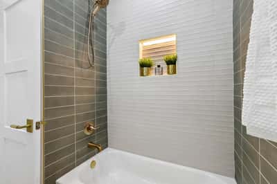 Contemporary bathroom featuring modern fixtures, a built-in niche for toiletries, and sleek tile accents.