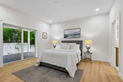 Bright and airy bedroom featuring large sliding doors, designed for comfort and modern living.