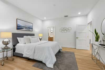 Spacious bedroom featuring modern decor, ample natural light, and a comfortable atmosphere for relaxation.