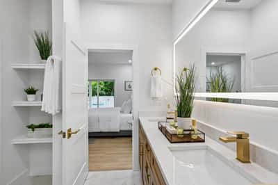 Modern bathroom featuring sleek finishes, abundant natural light, and a seamless view into the adjoining room.