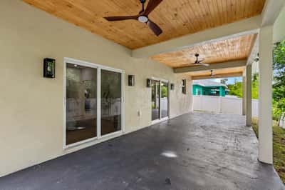 Spacious covered patio with ceiling fans, perfect for outdoor gatherings and enjoying the fresh air.