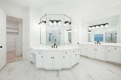 Spacious primary bathroom featuring dual vanities, modern fixtures, and abundant natural light for a refreshing retreat.