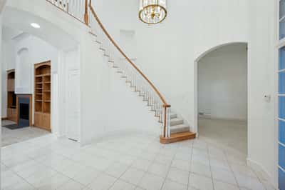 This spacious entryway features a grand staircase and abundant natural light, perfect for welcoming guests.
