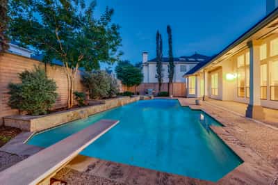 Discover a refreshing outdoor oasis featuring a spacious pool surrounded by lush landscaping, perfect for entertaining.