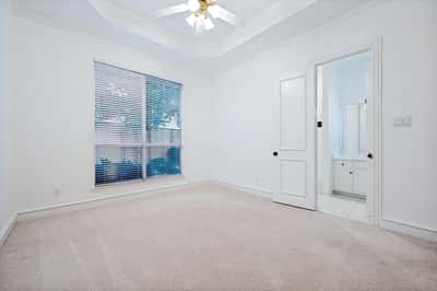 Bright and spacious bedroom featuring a ceiling fan and direct access to a connected bathroom.