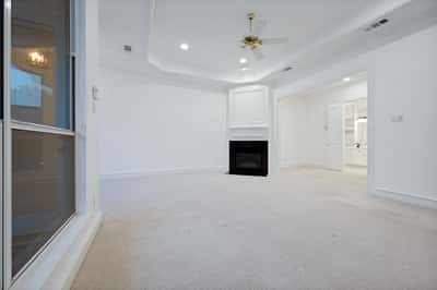 Spacious living area featuring a cozy fireplace and natural light from large windows.