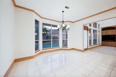 Spacious dining area with large windows, offering abundant natural light and views of the backyard.
