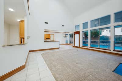 Spacious living area with tall ceilings and abundant natural light, ideal for comfortable gatherings and entertaining.
