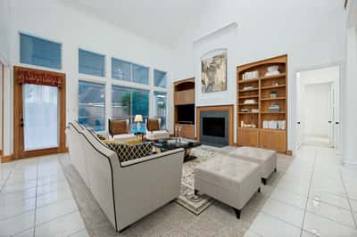 Bright and inviting living area features a cozy fireplace, built-in shelving, and generous natural light.