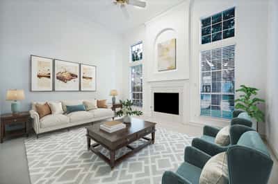 Bright, spacious living room featuring large windows, modern furnishings, and a cozy fireplace for gatherings.
