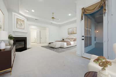 Spacious primary bedroom featuring a cozy fireplace and seamless access to a private sitting area.