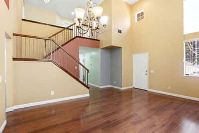 Spacious living area with high ceilings and an inviting staircase, perfect for entertaining and gathering.