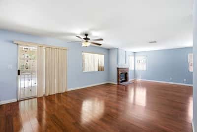 Spacious living area features warm hardwood floors, a cozy fireplace, and abundant natural light.