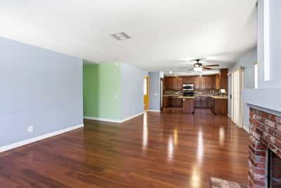 Spacious open-concept living area seamlessly connects kitchen and dining, featuring hardwood floors and natural light.