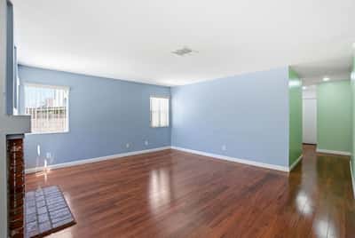 Spacious living area with fresh paint and hardwood floors, perfect for your personal touch and gatherings.