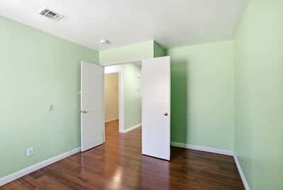 Bright, inviting room with versatile layout, featuring new flooring and fresh green walls to inspire creativity.