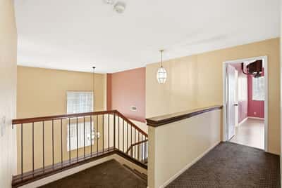 Spacious hallway featuring natural light, unique color accents, and access to multiple living areas.