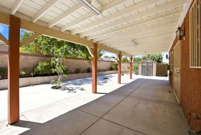 Spacious covered patio area with ample room for outdoor activities and potential for landscaping creativity.