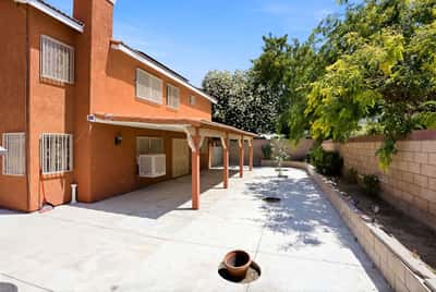 Spacious backyard featuring covered patio, perfect for outdoor gatherings and relaxation in a prime neighborhood.