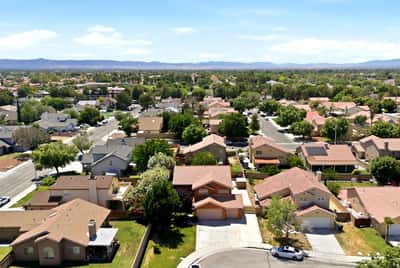 Spacious neighborhood featuring a mix of modern homes, lush trees, and scenic mountain views.