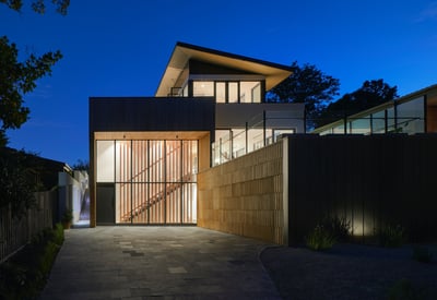 Stunning modern home featuring sleek design, warm lighting, and lush surroundings, perfect for contemporary living.