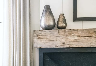 Stylish mantle featuring elegant metallic vases and rustic wood, enhancing the home's contemporary charm.