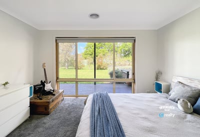 Bright bedroom featuring a large window with garden views, complemented by modern furnishings and cozy atmosphere.