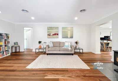 Bright and spacious living area featuring warm wooden floors, modern artwork, and an inviting atmosphere.