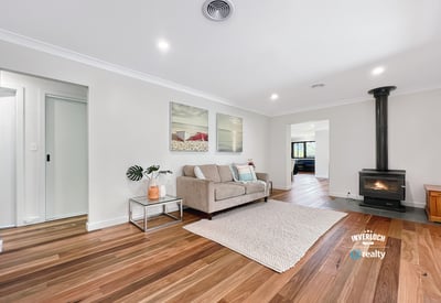 Spacious living area featuring hardwood floors and a cozy wood-burning stove, perfect for gatherings and relaxation.