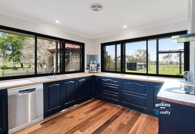 Modern kitchen with panoramic windows, featuring sleek cabinetry and scenic views of the surrounding landscape.