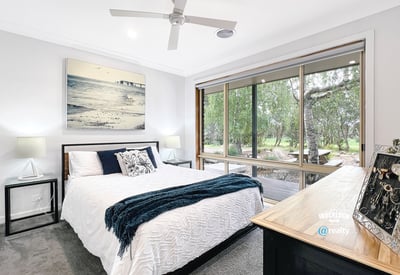 Bright bedroom with large windows offering scenic views and modern finishes for comfortable living.