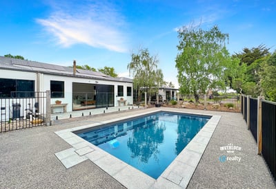 This contemporary home features a spacious outdoor area with a pristine pool and landscaped surroundings.